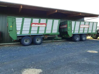 Silagetransportwagen mit Lagerhalle im Hintergrund